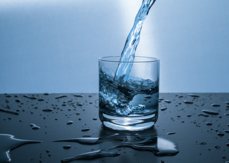 Um copo com água potável remetendo à falta de água potável e à importância de reaproveitamento da água