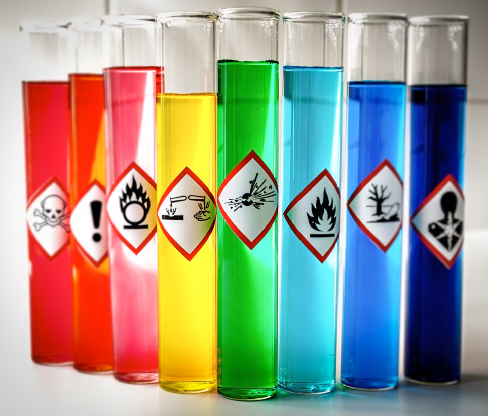 Vários tubos de ensaio com produtos químicos etiquetados de acordo com sua periculosidade.